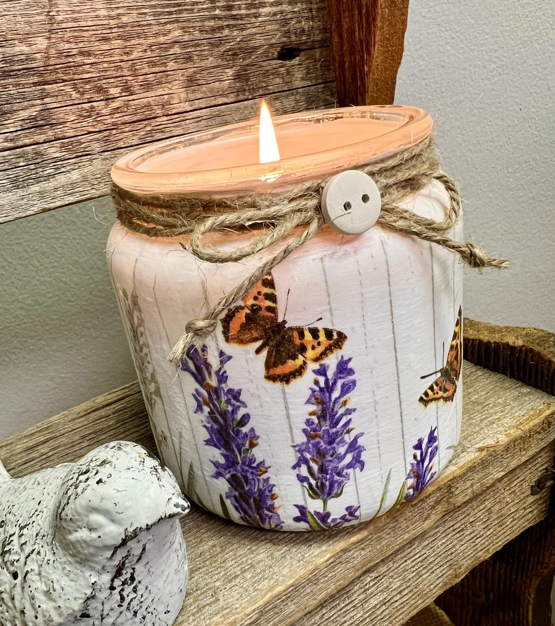 candle container napkinized with purple flowers and a butterfly